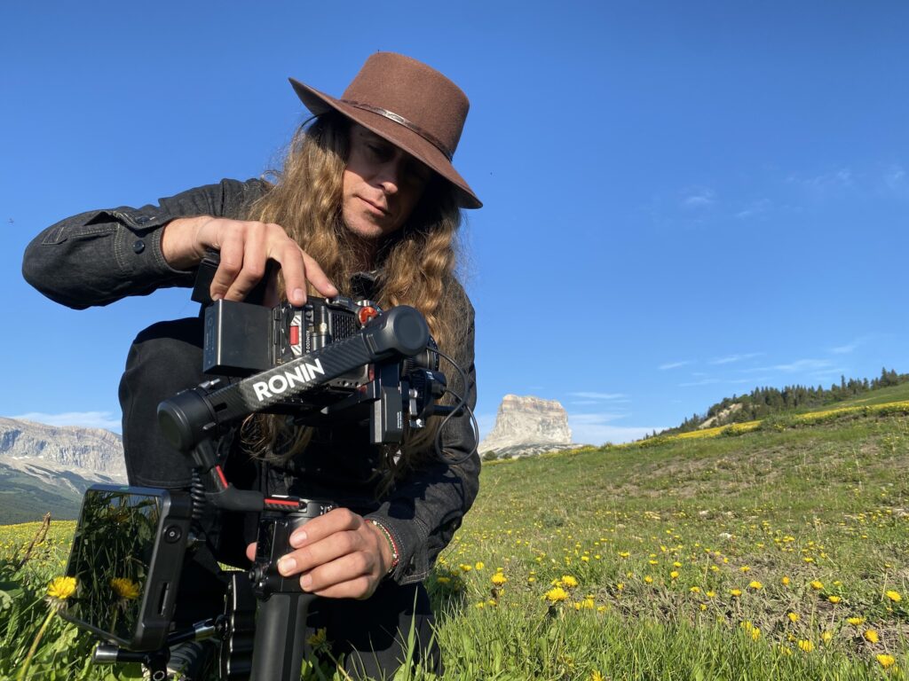 Kier Atherton operating a RED Komodo on a DJI Ronin gimbal in a wildflower meadow below Chief Mountain, Northwest Montana